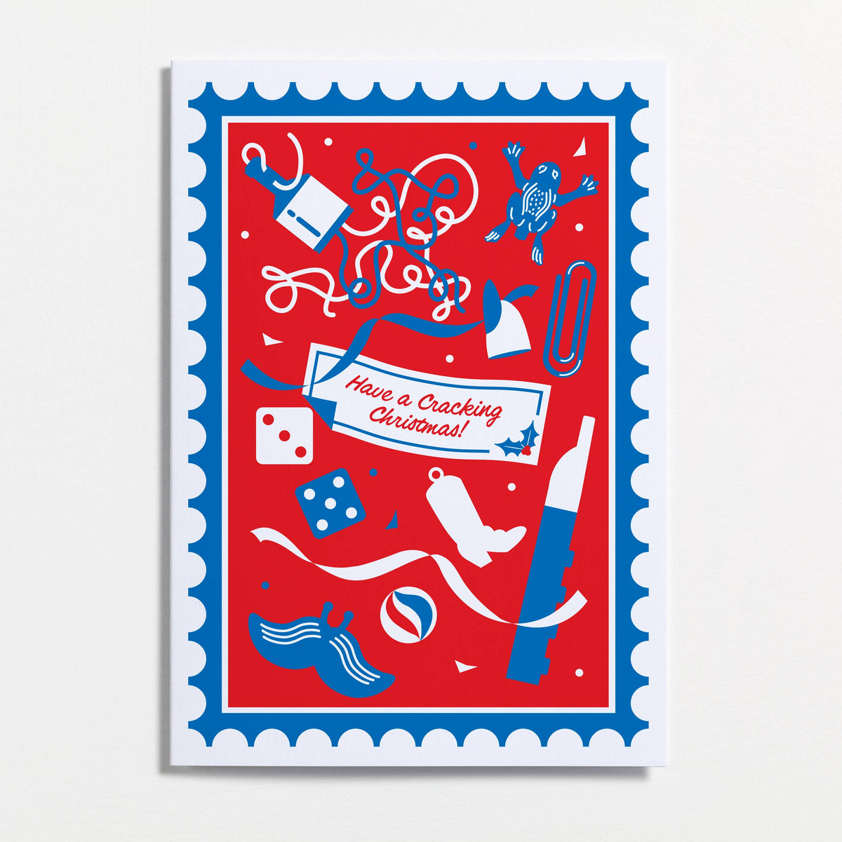 A festive Christmas greeting card with a red background, blue and white scalloped border, and playful holiday illustrations including a gift box, stocking, ornaments, dice, and a banner reading 'Have a Cracking Christmas!'. Designed by Crispin Finn