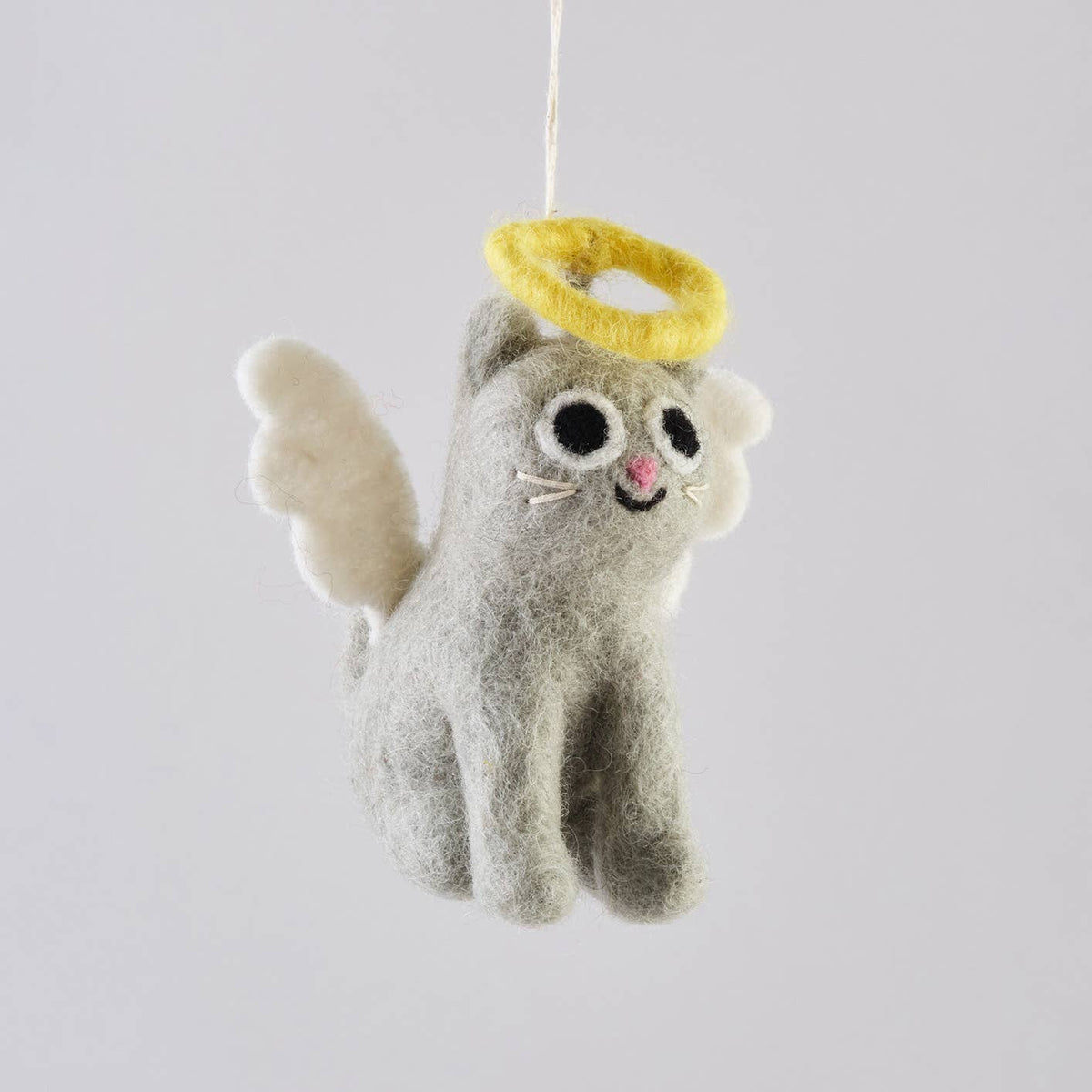 A gray felt cat ornament styled as an angel, featuring a yellow felt halo, white wings, and embroidered facial details, suspended by a thin white string against a light gray background.